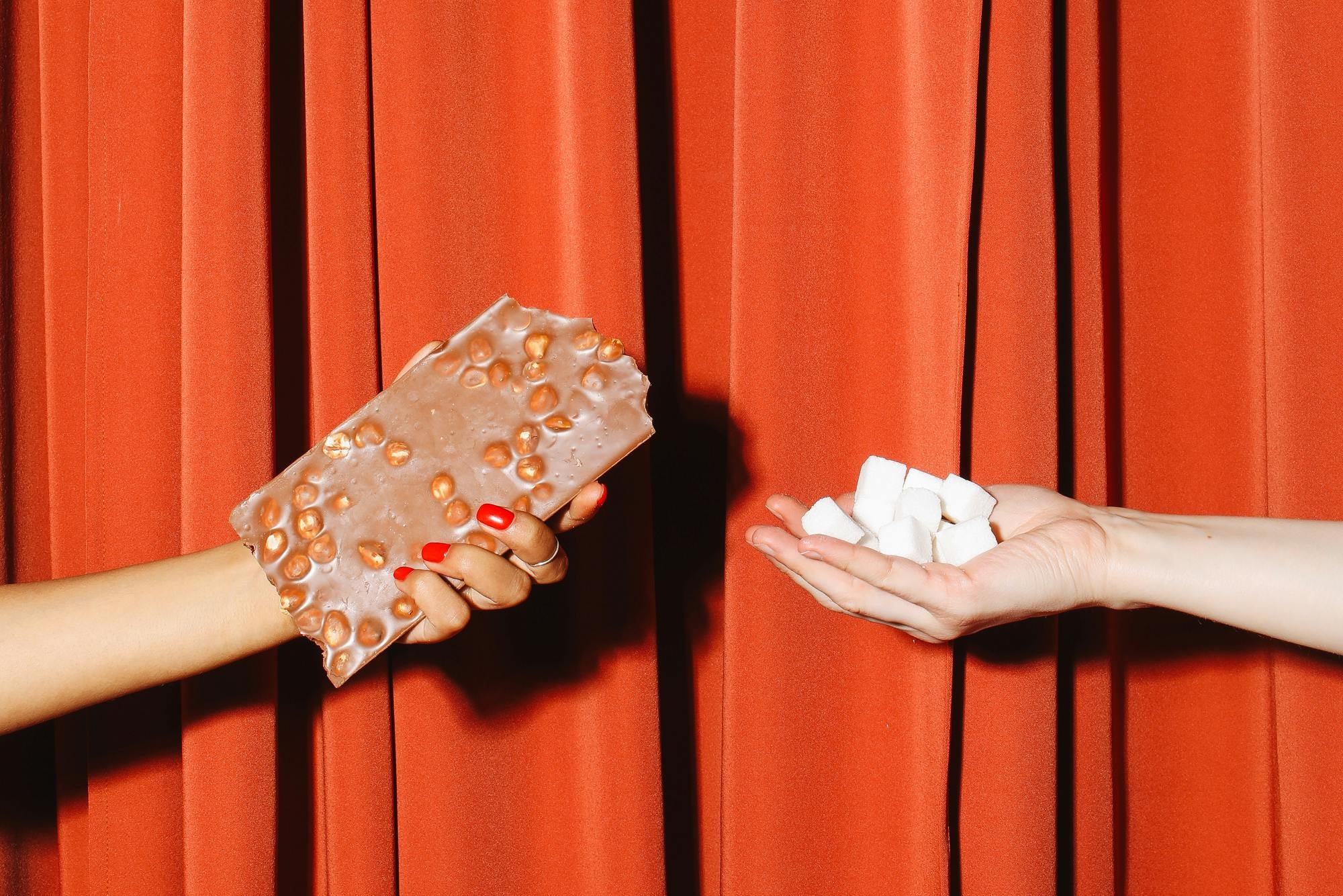 a person holding a chocolate bar and sugar