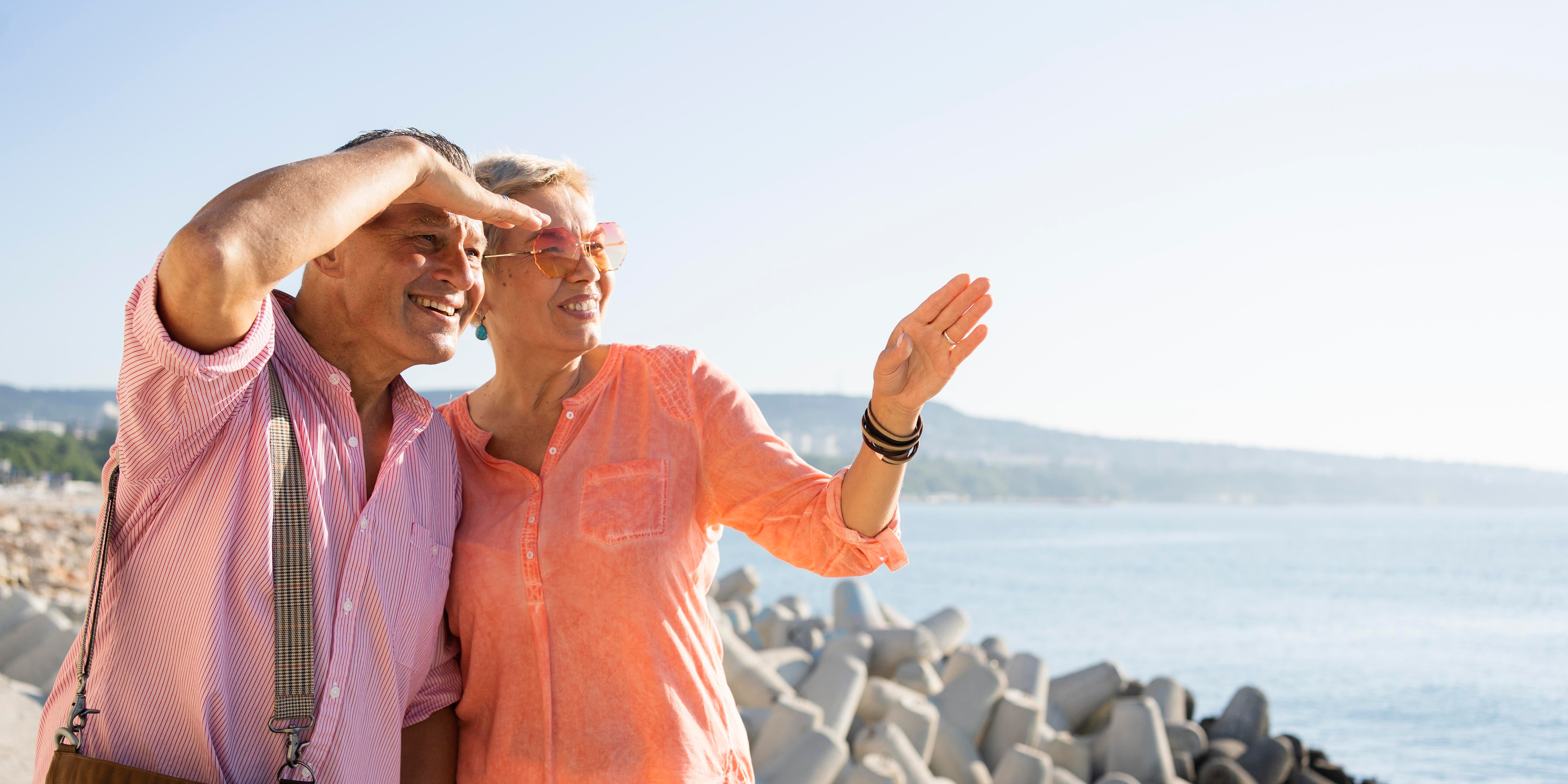 Medium shot of a couple standing together and looking away, appearing thoughtful in a calm, natural setting
