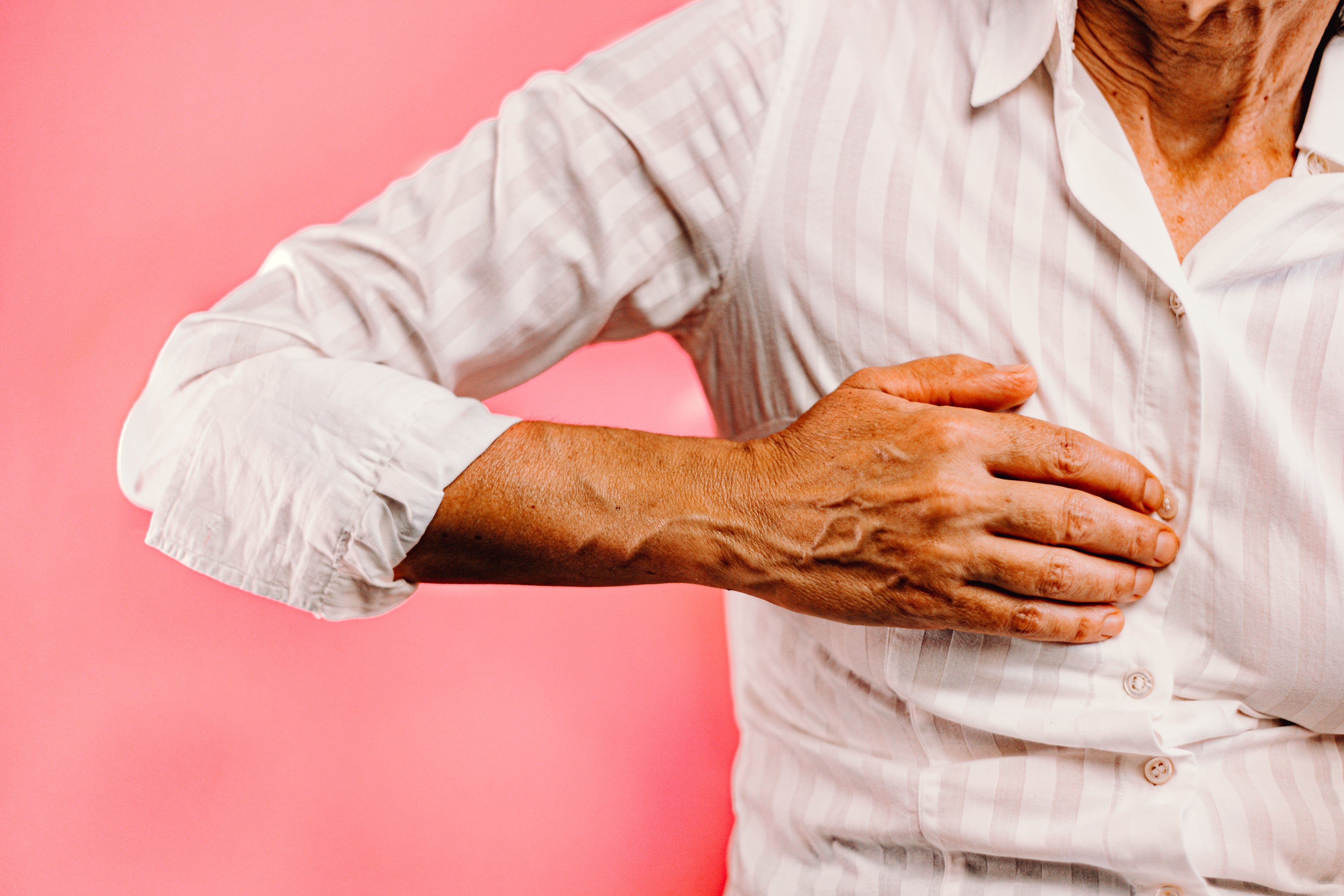 Person holding one hand on their chest, possibly indicating awareness of heart health, breathing, or a moment of discomfort